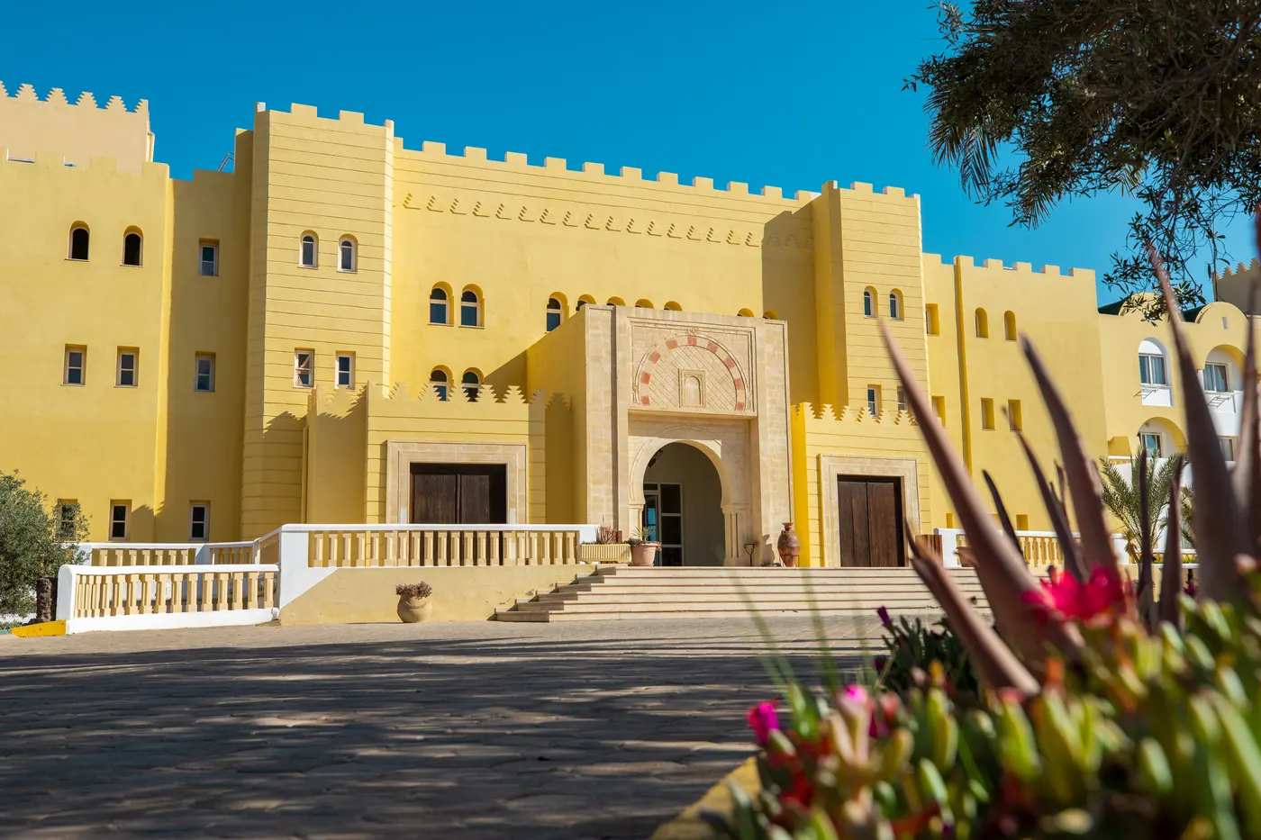 Entrée monumentale et arches arabo-andalouses blanchies à la chaux de l'Hôtel Djerba Castille 4 étoiles à Aghir